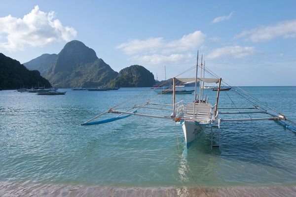 Bangka moored off Corong-Corong Beach with Bacuit Bay islands behind
