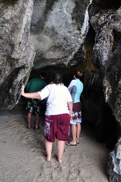 Visitors stooping into the low entrance of Cudugnon Cave