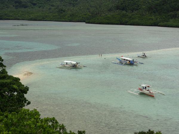 Snake Island sandbar seen from the island's hilltop trail, with outrigger boats anchored in shallow turquoise water