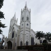 Cathedral with twin pointed spires and a painted white facade, seen from the street corner on Rizal Avenue