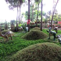 Dinosaur sculptures among mossy mounds and clipped ground cover in the landscaped garden park at Baker's Hill